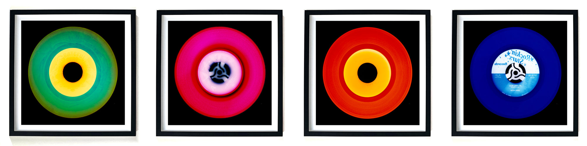 Photographs by Heidler and Heeps. A horizontal line of 4 photographs of vinyls in striking colours, with black frames. 