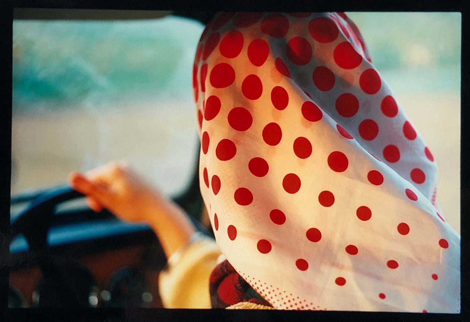 Richard Heeps photograph of a woman driving a car wearing a vintage polka dot headscarf.