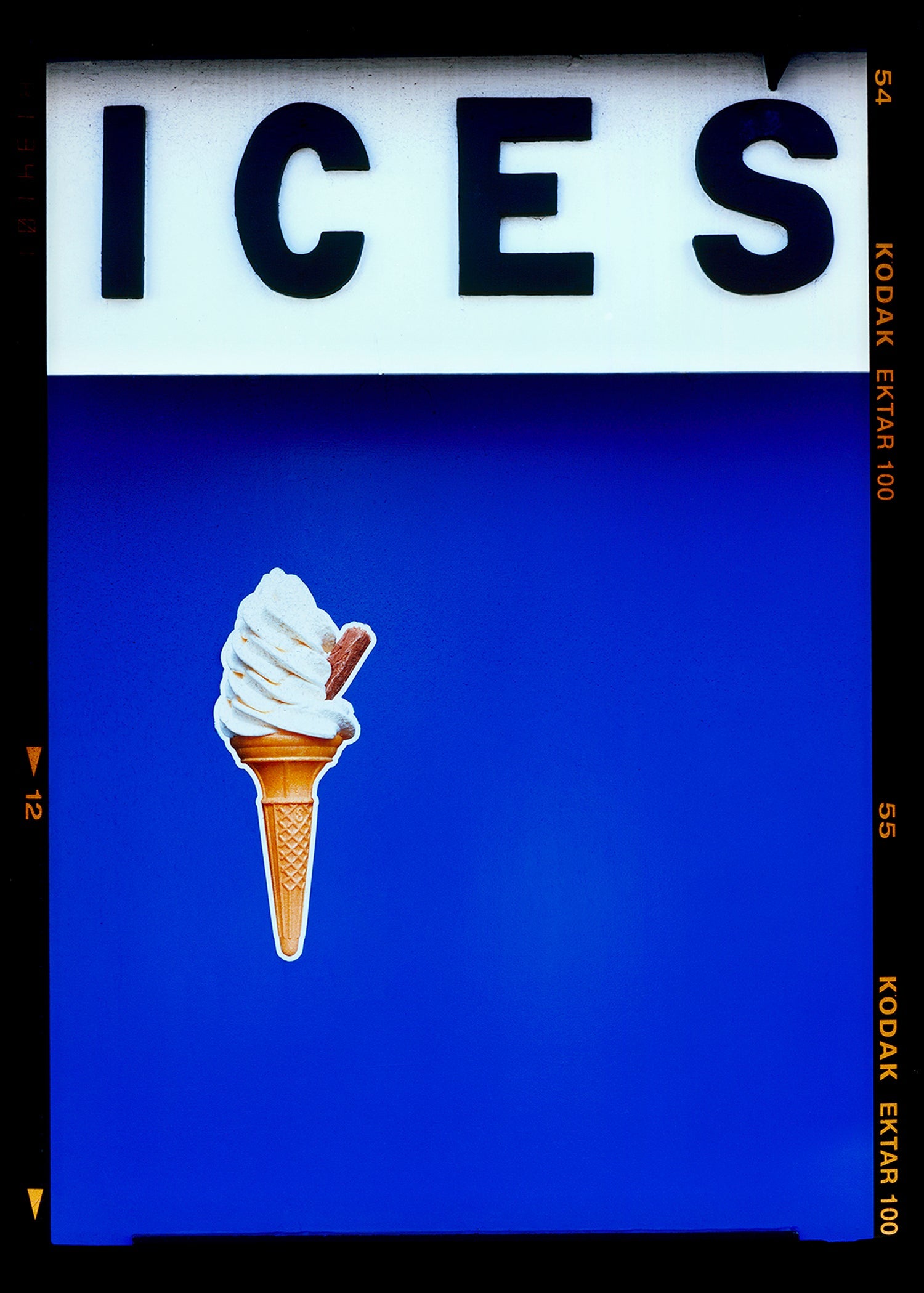 Photograph by Richard Heeps.  At the top black letters spell out ICES and below is depicted a classic ice cream cone with a flake sitting left of centre against a blue coloured background.  