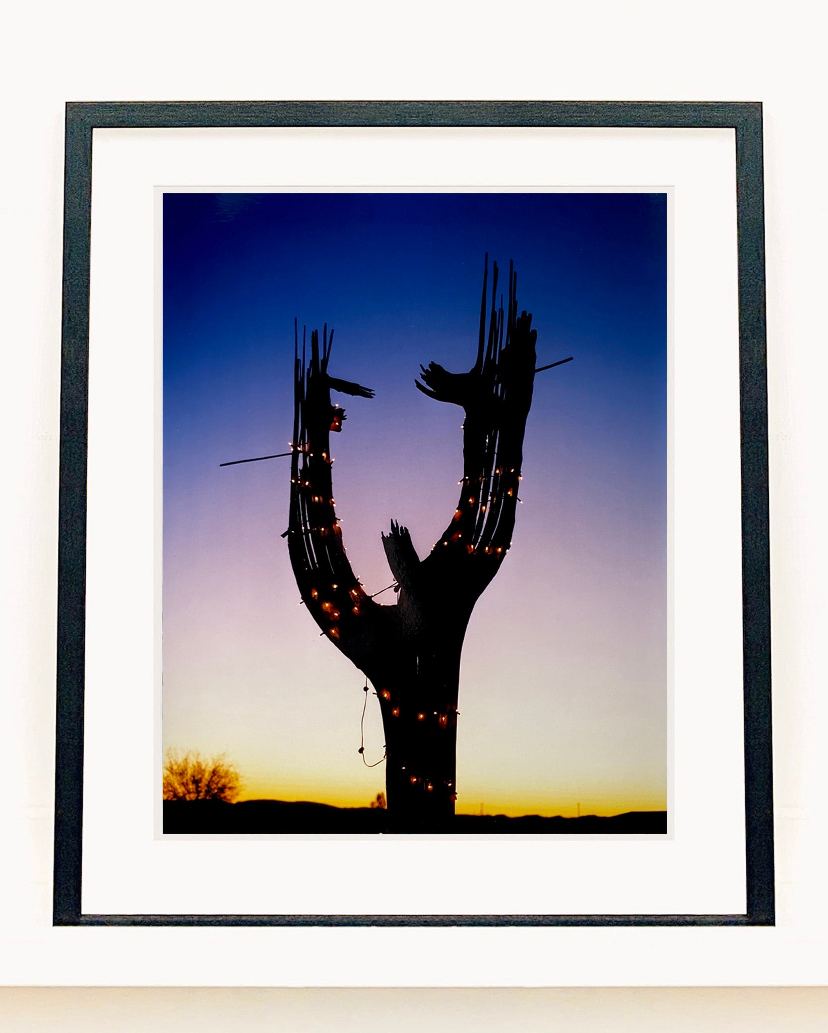 The silhouette of a large scale cactus, dressed in twinkle lights, set against an ombre twilight sky. Photographed by Richard Heeps in the Arizona desert, for his 'Dream in Colour' series.