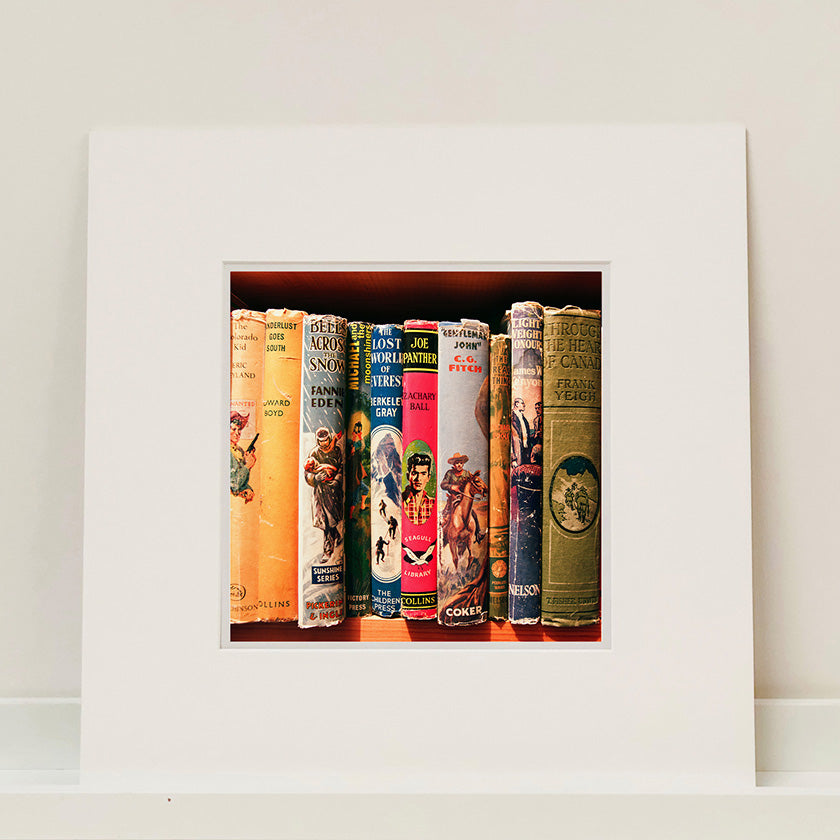 Mounted photograph of vintage book spines on a shelf by Richard Heeps.