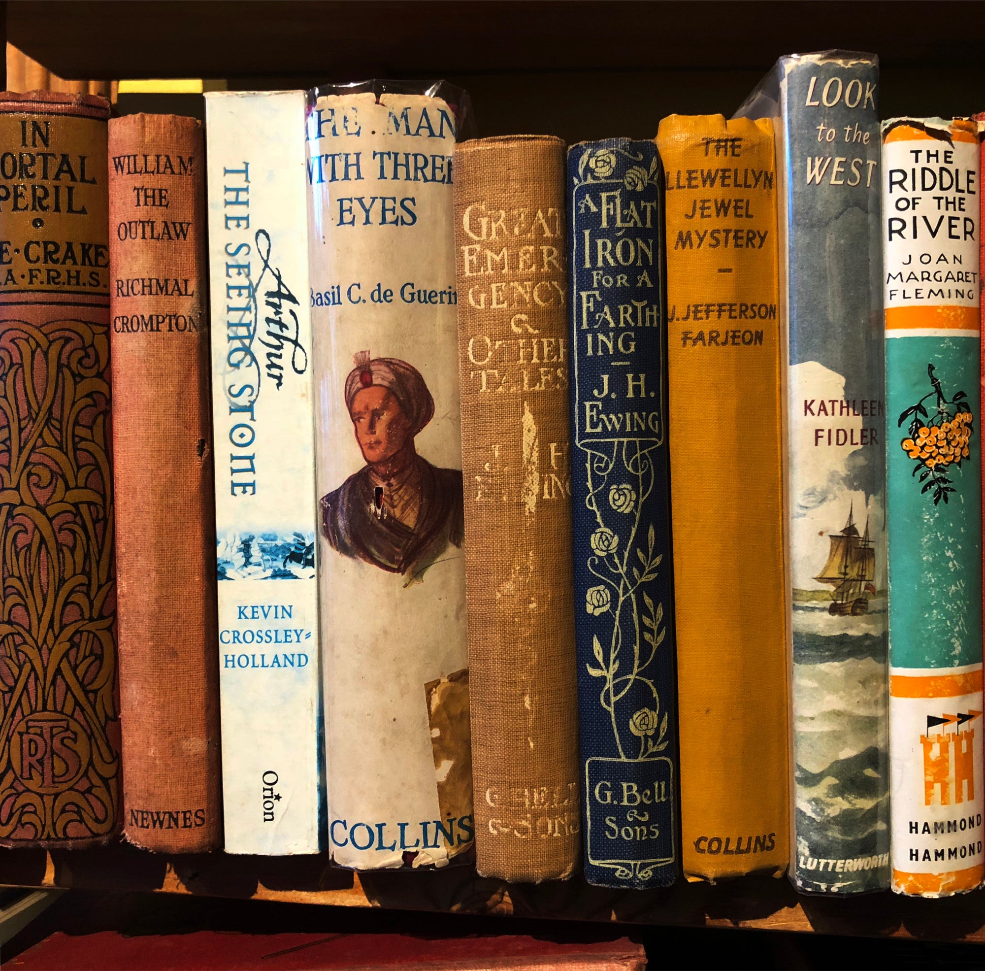 'The Riddle of the River' showcases the well worn spines of vintage books on a shelf, photographed by Richard Heeps in a secondhand bookshop in the Norfolk village Burnham Market.