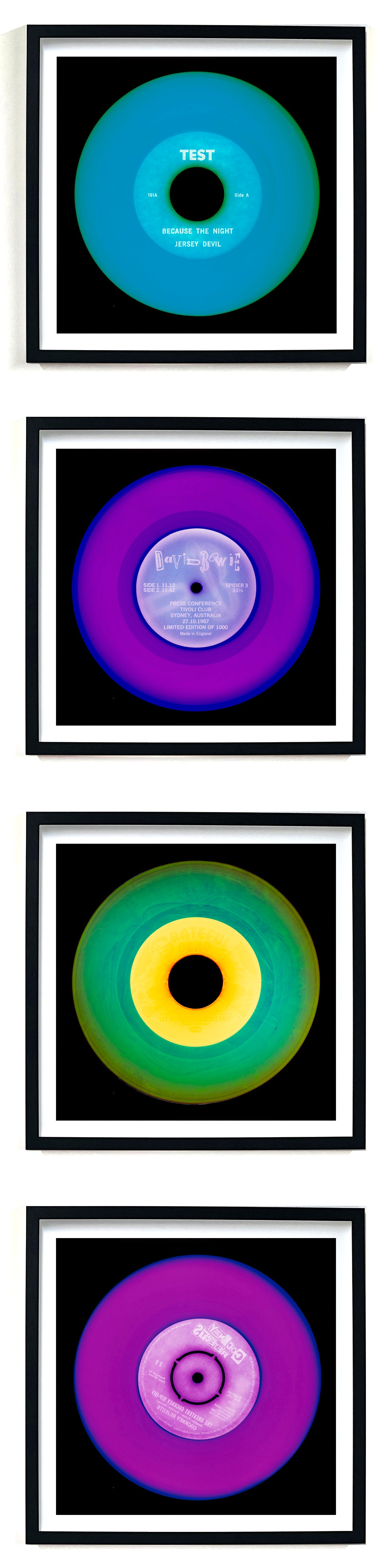 Photographs by Heidler and Heeps. A vertical line of 4 photographs of vinyls in striking colours, with black frames. 