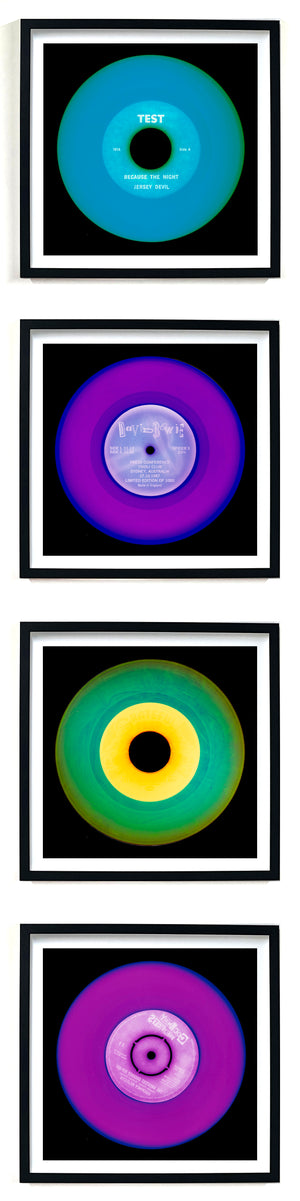 Photographs by Heidler and Heeps. A vertical line of 4 photographs of vinyls in striking colours, with black frames. 