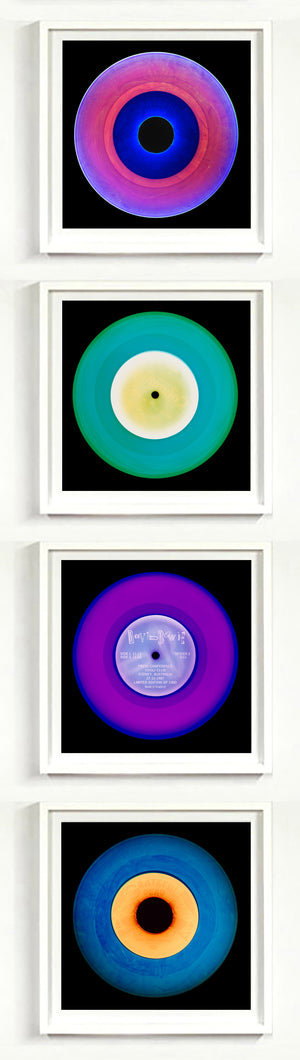 Photographs by Heidler and Heeps. A vertical line of 4 photographs of vinyls in striking colours, with black frames. 