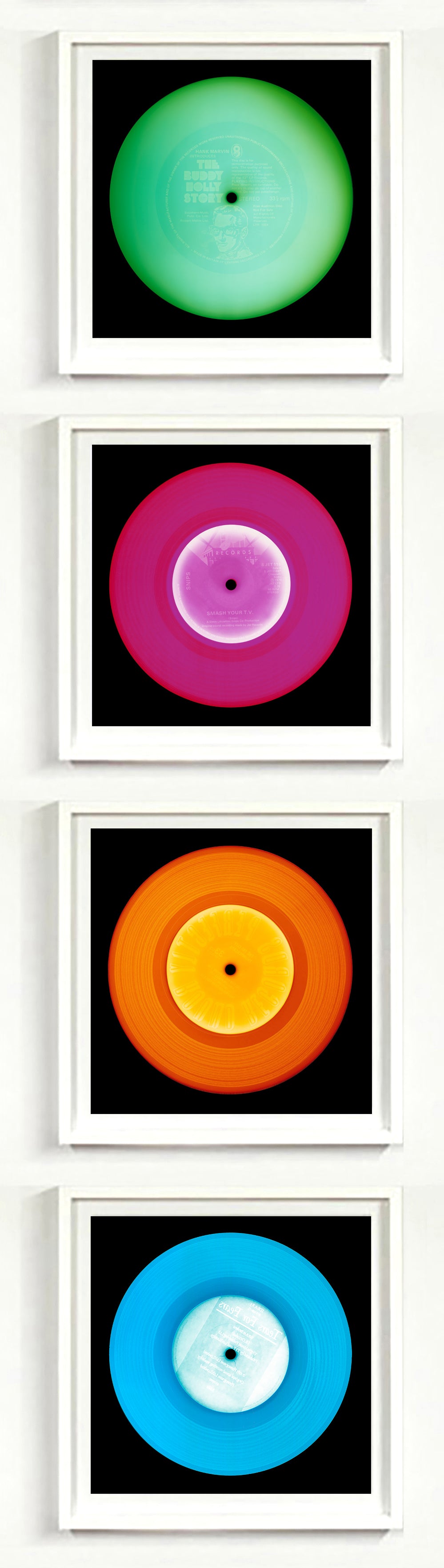 Photographs by Heidler and Heeps. A vertical line of 4 photographs of vinyls in striking colours, with black frames. 