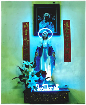 Photograph by Richard Heeps. Ave Maria, with a neon halo and name 'Ave Maria' at her feet. The neon tones the photo in green and blue.