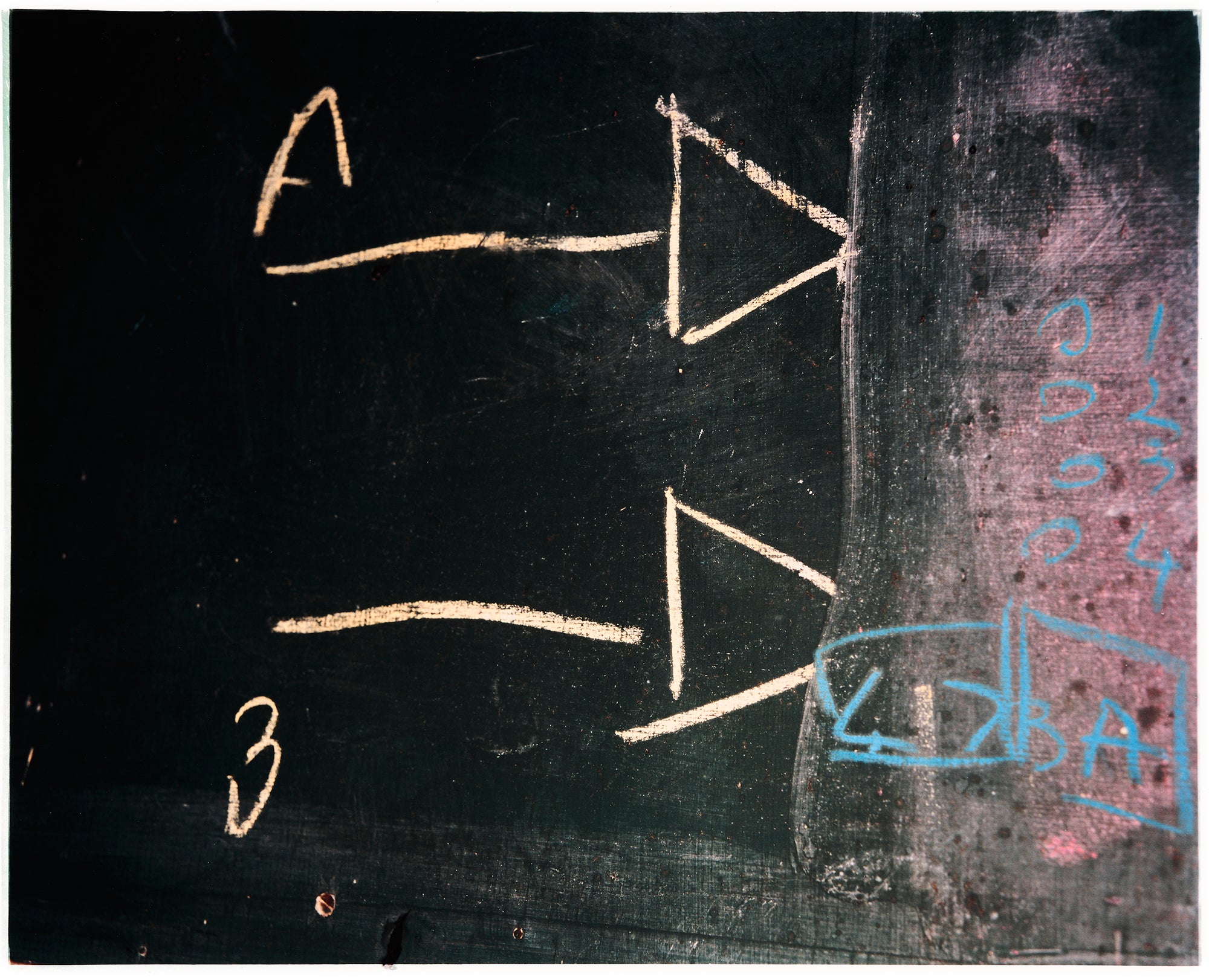 Photograph by Richard Heeps. A blackboard with two white chalk arrows sitting one on top of the other, one labelled A and the other labelled B. Both pointing into a white smudged drawn block on the right hand side.