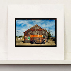 Model T and Garage American road trip colour Kodak Film photograph by Richard Heeps mounted square