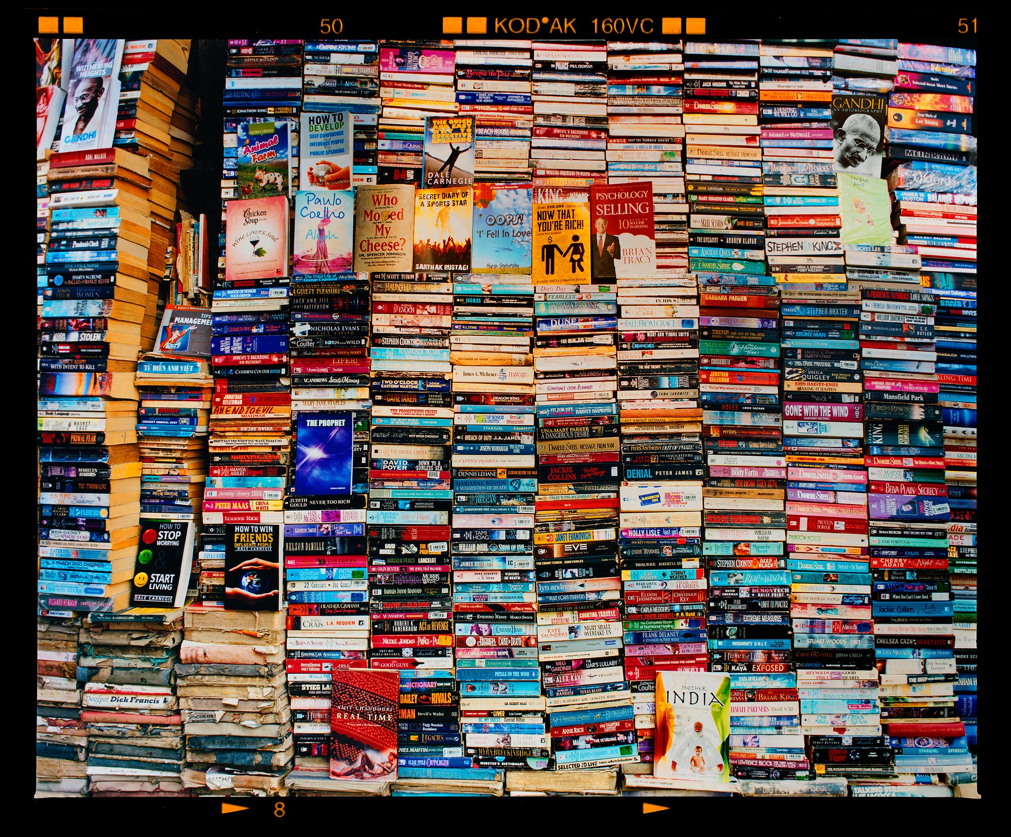 Mother India Delhi street photography multicolour book stack photograph by Richard Heeps
