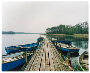 Ormesby Little Broad, a docking jetty with small boats stretches out to the Norfolk Broad photograph by Richard Heeps.