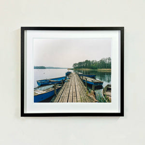Ormesby Little Broad, a docking jetty with small boats stretches out to the Norfolk Broad photograph by Richard Heeps small framed in black.
