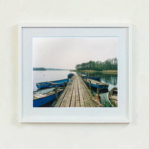 Ormesby Little Broad, a docking jetty with small boats stretches out to the Norfolk Broad photograph by Richard Heeps small framed in white.