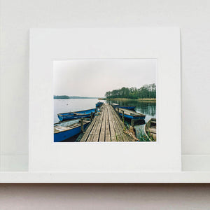 Ormesby Little Broad, a docking jetty with small boats stretches out to the Norfolk Broad photograph by Richard Heeps mounted square.