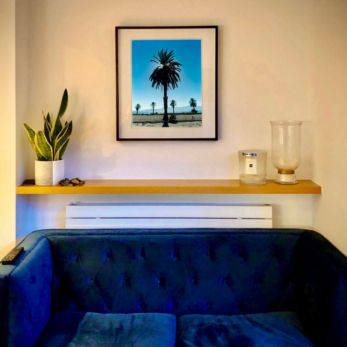 Palm tree silhouette against a bright blue California sky Salton Sea black frame on a living room wall photograph by Richard Heeps.