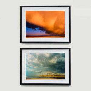 Two framed artworks of cloudscapes on a white wall Norfolk landscape photographs by Richard Heeps.