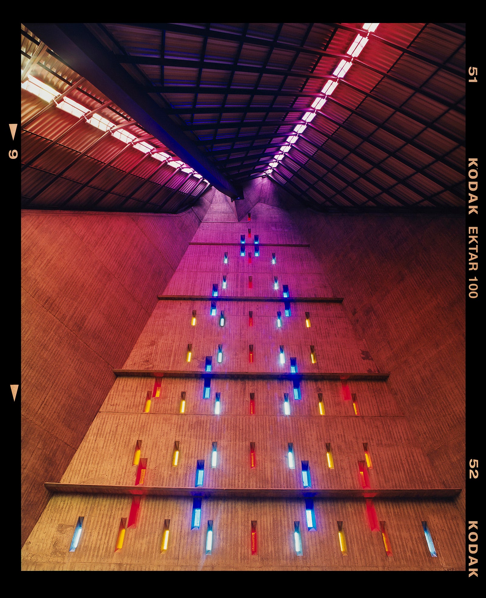 Photograph by Richard Heeps. Stained glass windows on the interior of San Giovanni Bono Church, a concrete brutalist building in Milan by Italian architect Arrigo Arrighetti. 