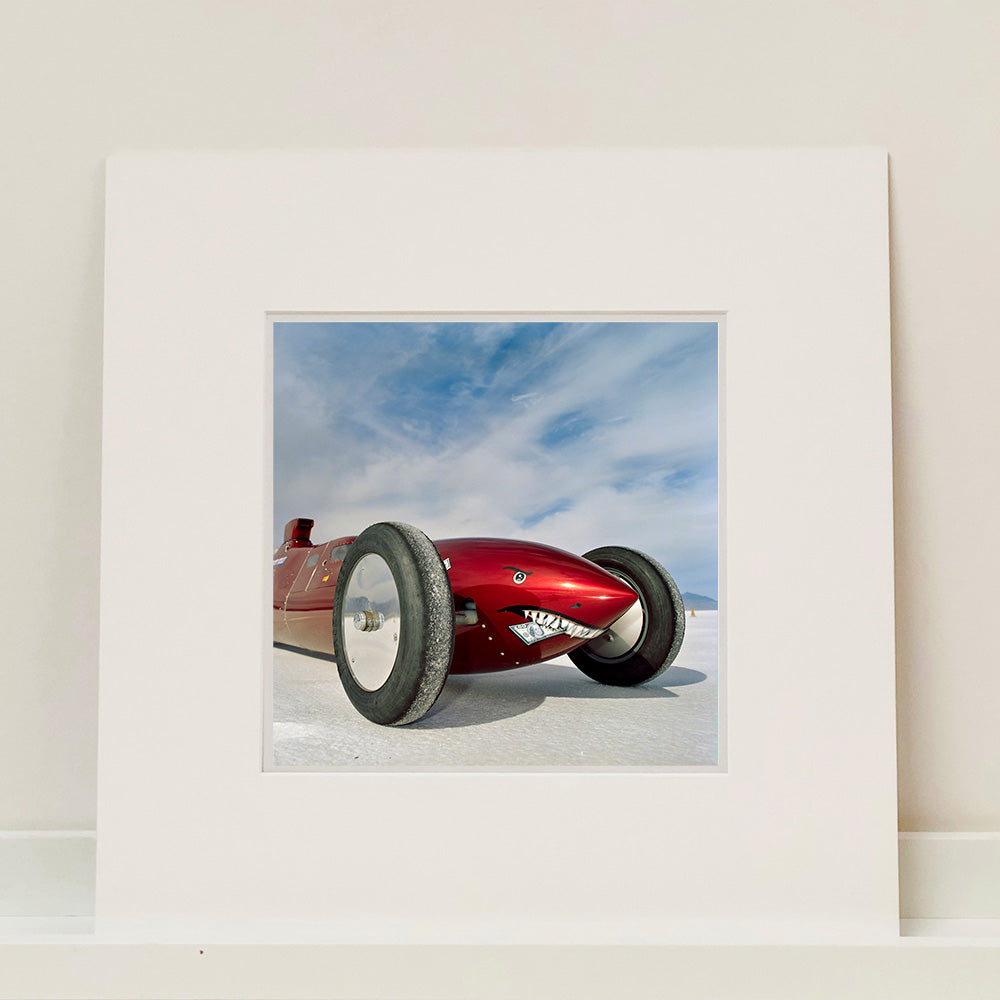 Mounted photograph by Richard Heeps.  The side on front of a red belly tank racing car, it is designed as a shark eating a $100 bill.