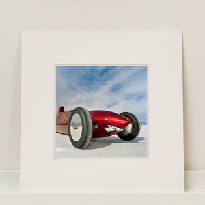 Mounted photograph by Richard Heeps.  The side on front of a red belly tank racing car, it is designed as a shark eating a $100 bill.