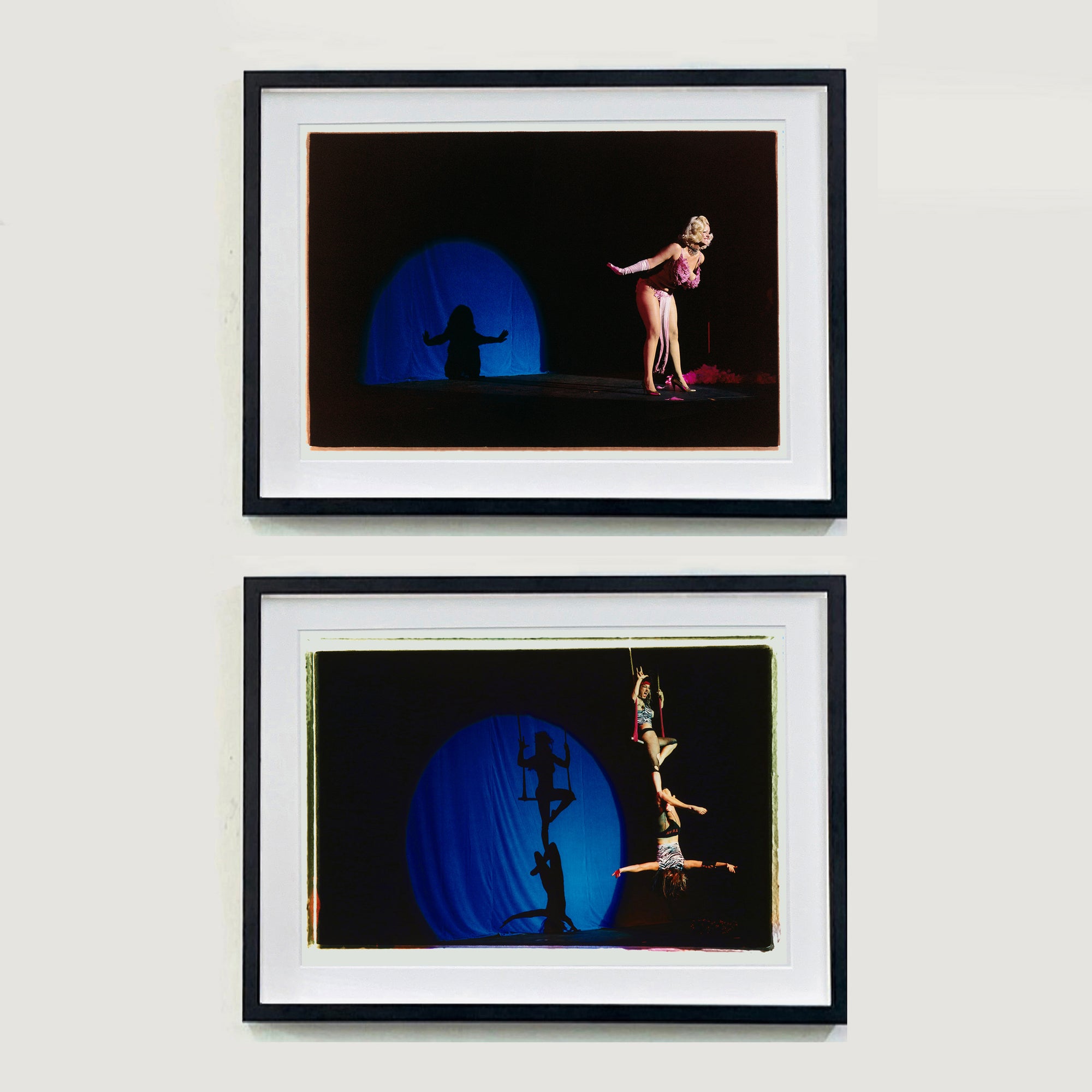 Two photograhs by Richard Heeps. The top photograph depicts a Burlesque dancer with a pink fluffy bikini who bows on a black stage, in the background is a blue circle containing her silhouette. The bottom photo has a pair of dancers on a trapeze, one is sitting on the swing and the other dangling below. The stage is dark and there is a blue circle behind them with their silhouettes in.