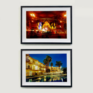 Two Black framed photographs by Richard Heeps. The top photograph is the shell shape of the front of La Concha hotel taken at night and bathed in golden and reddish brown colours. The bottom photograph is an evening view of a hotel and it's pool. The golden lit hotel is reflected in the pool. There are a few palm trees around the pool. 