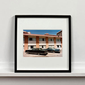 Black framed photograph by Richard Heeps. This retro photograph has two classic Lincoln cars parked outside a hotel in Las Vegas. 