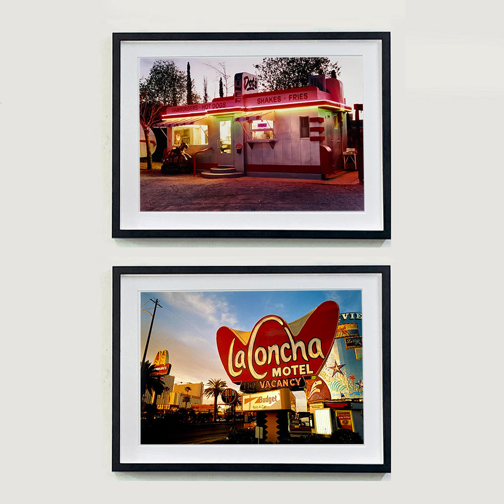Two Black framed photographs by Richard Heeps. The top one depicts a one storey small building "Dot's Diner" brightly lit with a pink roof, with Hamburgers, Hot Dogs, Shakes, Fries written along the top of the building. The bottom photograph is the outside of LaConcha Motel which is written in a big red sign with golden writing, below the sign is VACANCY written in red, below this sits a sign for Budget rent a car.
