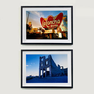 Two black framed photograph by Richard Heeps. The top photograph is of the outside of La Concha Motel. The gold flamboyant La Concha lettering is set on a big red background. Below the motel sign is NO VACANCY with just VACANCY lit in red, below this sits a sign for Budget rent a car. Other signs and palm trees are the background together with a blue sky. The bottom photograph is the derelict Cook Bank Building the remnants of which sits derelict alone, surrounded by rubble and gravel in a blue light.