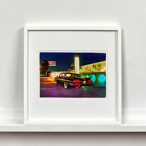 White framed photograph by Richard Heeps. A Chevy Bel Air is central shot and off to the right are the pools and balcony of the Glass Pool Motel, Las Vegas.