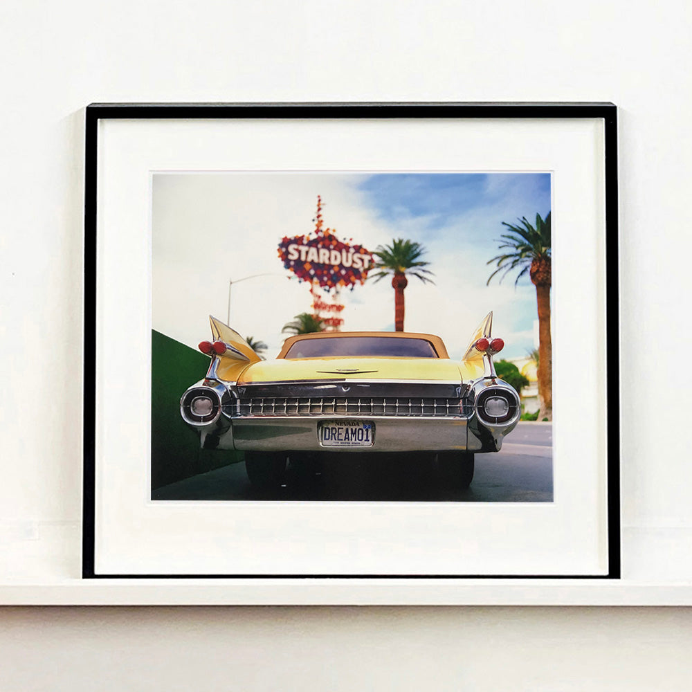 Black framed photograph by Richard Heeps.  The back end of the classic American car with a number place DREAM01 sits underneath the STARDUST casino sign.