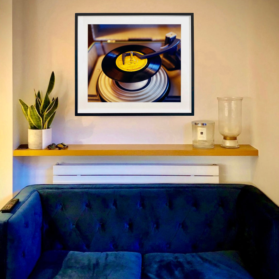 In situ black framed photograph by Richard Heeps. A black vinyl with a yellow label sits high on the spindle of a deck under the overarm.