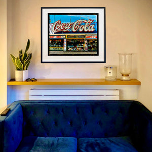 In situ black framed photograph by Richard Heeps. Harry's Corner was taken on the wildwood boardwalk, featuring neon typography and the iconic Coca-Cola sign against a bright blue sky. 