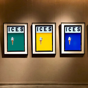 Set of three photographs by Richard Heeps.  Three identical photographs (apart from the block colour), at the top black letters spell out ICES and below is depicted a 99 icecream cone sitting left of centre set against, in turn, a deep green teal, yellow and blue coloured background.  