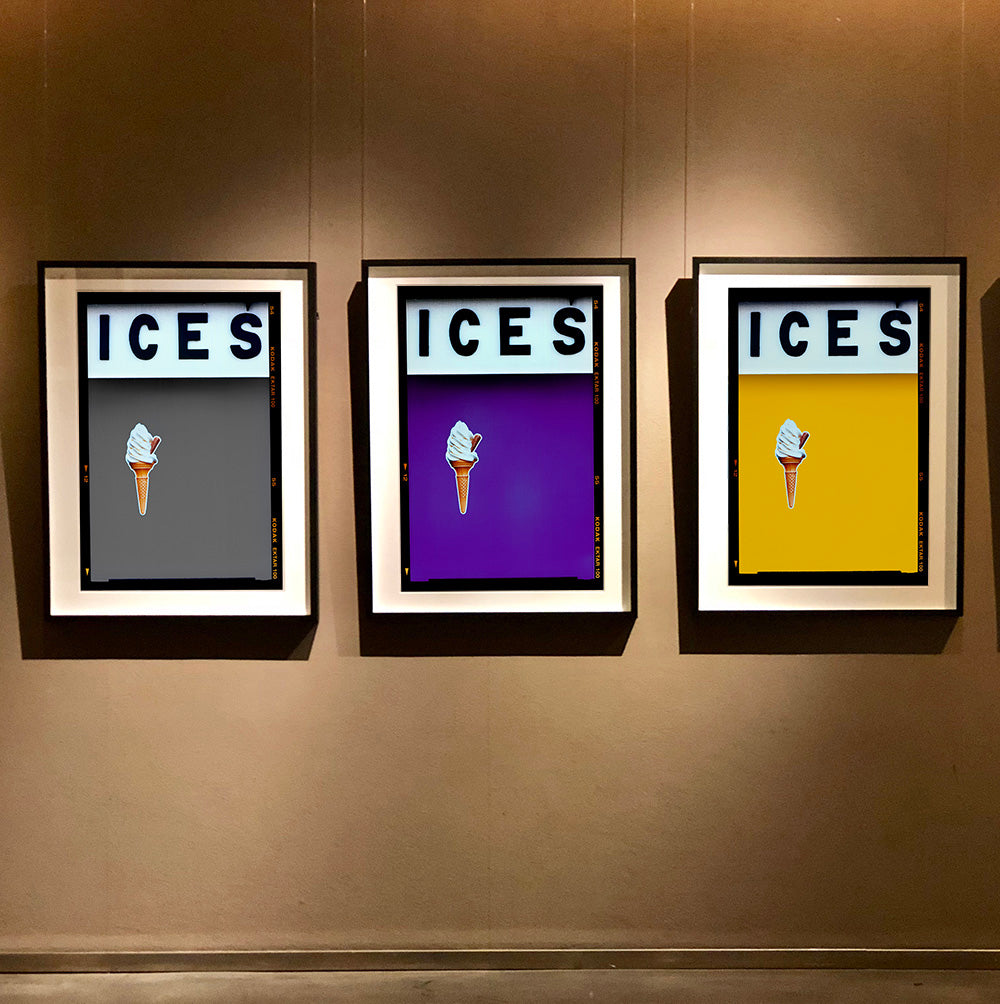 Set of three photographs by Richard Heeps.  Three identical photographs (apart from the block colour), at the top black letters spell out ICES and below is depicted a 99 icecream cone sitting left of centre set against, in turn, a grey, plum and yellow coloured background.  