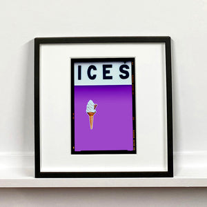 White framed photograph by Richard Heeps.  At the top black letters spell out ICES and below is depicted a 99 icecream cone sitting left of centre against a lilac coloured background.  