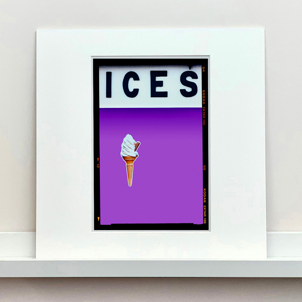 Mounted photograph by Richard Heeps.  At the top black letters spell out ICES and below is depicted a 99 icecream cone sitting left of centre against a lilac coloured background.  