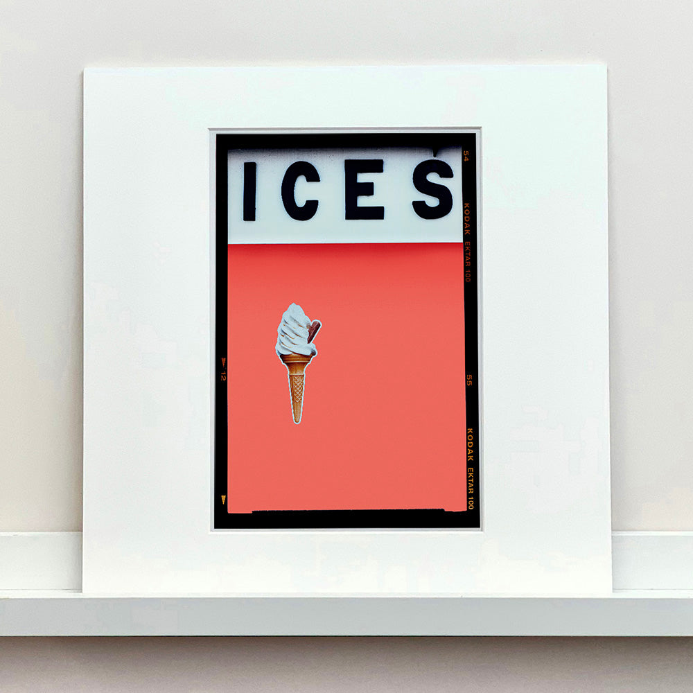 Photograph by Richard Heeps.  At the top black letters spell out ICES and below is depicted a 99 icecream cone sitting left of centre against a melondrama red orange coloured background.  