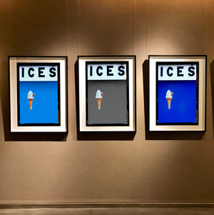 Set of three photographs by Richard Heeps.  Three identical photographs (apart from the block colour), at the top black letters spell out ICES and below is depicted a 99 icecream cone sitting left of centre set against, in turn, a sky blue, grey and blue coloured background.  