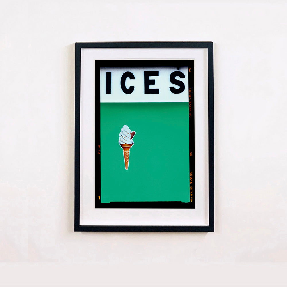 Black framed photograph by Richard Heeps.  At the top black letters spell out ICES and below is depicted a 99 icecream cone sitting left of centre against a viridian green coloured background.  