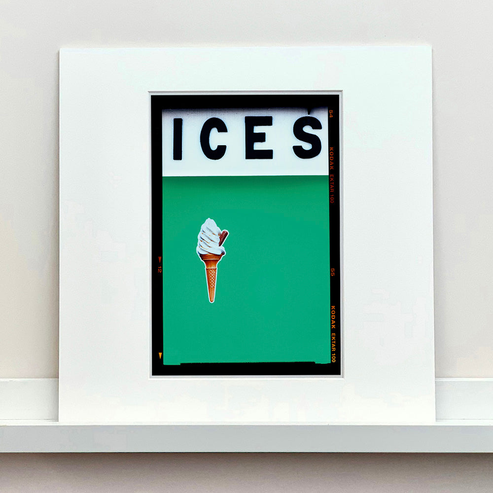 Mounted photograph by Richard Heeps.  At the top black letters spell out ICES and below is depicted a 99 icecream cone sitting left of centre against a viridian green coloured background.  