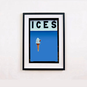 Black framed photograph by Richard Heeps.  At the top black letters spell out ICES and below is depicted a 99 icecream cone sitting left of centre against a baby blue coloured background.  