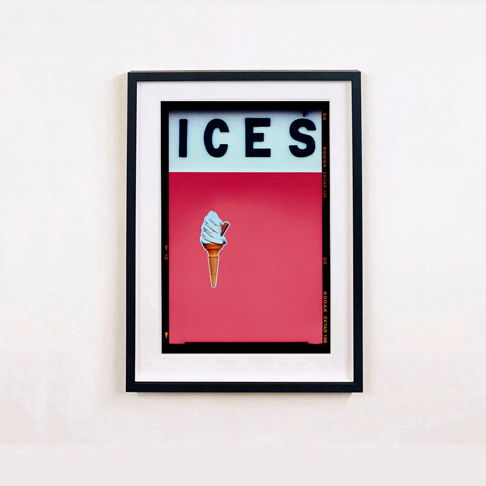 Black framed photograph by Richard Heeps.  At the top black letters spell out ICES and below is depicted a 99 icecream cone sitting left of centre against a coral coloured background.  