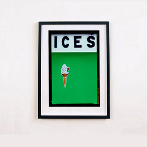 Black framed photograph by Richard Heeps.  At the top black letters spell out ICES and below is depicted a 99 icecream cone sitting left of centre against a green coloured background.  