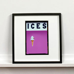 Black framed photograph by Richard Heeps.  At the top black letters spell out ICES and below is depicted a 99 icecream cone sitting left of centre against a plum coloured background.  