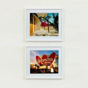 Two white framed photographs by Richard Heeps. On top a photograph of a flowering bougainvillea hangs outside a motel entrance.  On the bottom is a LaConcha Motel Vacancy sign with a Budget rent a car sign underneath taken in a golden setting sun.