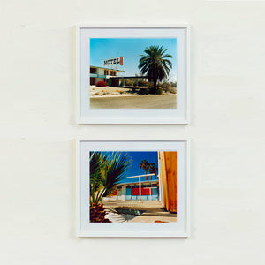 Two white framed photographs by Richard Heeps. The top photograph is of a derelict motel office sitting on a dusty American road. A large palm tree sits at the front of the office's walkway. The bottom photograph is the outside of a derelict motel, the building has strong colours on it and sits against a beautiful blue sky. There is a palm tree behind the motel and sitting to the left of the scene.