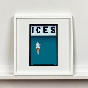 White framed photograph by Richard Heeps.  At the top black letters spell out ICES and below is depicted a 99 icecream cone sitting left of centre against a blue teal coloured background.  