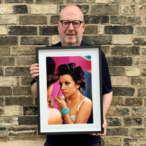 Richard Heeps holding Burlesque portrait photograph framed in black