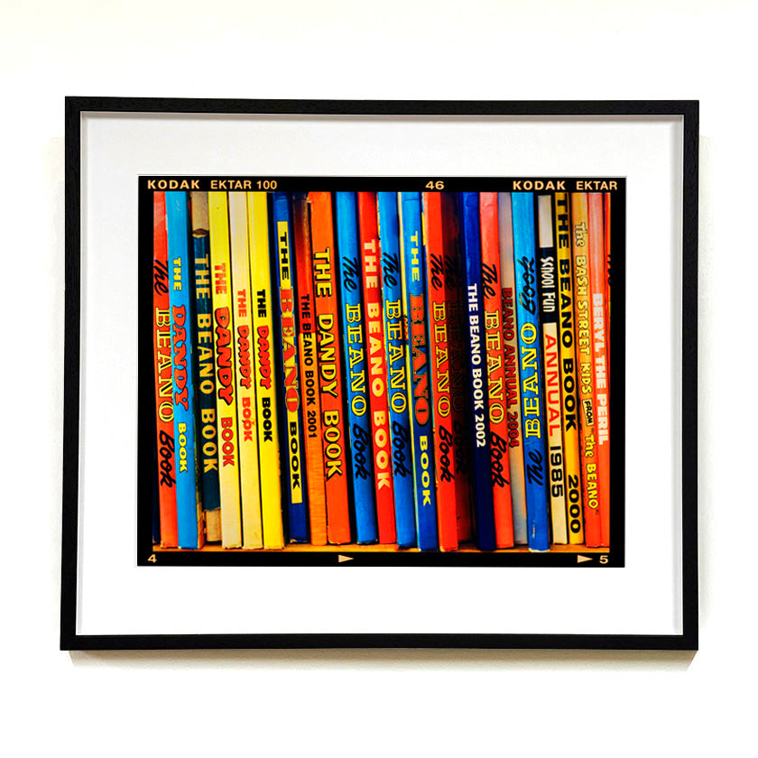 Vintage book spines multi-colour photograph by Richard Heeps framed in black.
