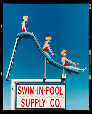 Photograph by Richard Heeps. A swimming pool sign featuring three retro women characters in red swimming costumes on a slide. At the bottom of the sign it reads SWIM-IN-POOL SUPPLY CO.